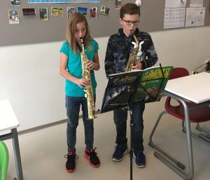 Gert leert zijn studenten de kneepjes van het saxofoon spelen