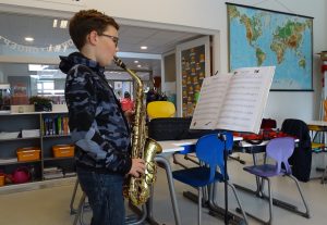 Een van de studenten is enthousiast saxofoon aan het spelen